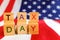 Tax day written with wooden letters to indicate the day of payment of taxes in america