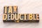 Tax deductible word abstract in wood type