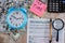 Tax form 1040, alarm clock, dollars, calculator and pen on the table. Close-up. View from above.