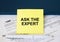 Tax form 1065 with yellow sticker with text Ask The Expert. Notepad and white pen