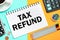 TAX REFUND with the office tools on yellow blue background . Concept TAX REFUND