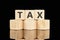TAX text assembled from wooden cubes on a black background