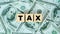 Tax word on wooden block.Income tax return.Tax time Concept.Government, state taxes. Data analysis, paperwork, financial research