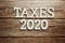 Taxes 2020 alphabet letter on wooden background