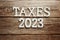 Taxes 2023 alphabet letter on wooden background