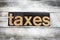 Taxes Letterpress Word on Wooden Background
