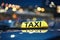 Taxi car on city street at night