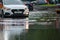 Taxi and cars in city traffic after heavy rain driving through flood