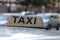 Taxi light sign or cab sign in brown color with black text and tied with wire on the car roof at the street