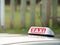 Taxi sign and aerial mounted ontop of a car with a reflection in