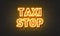 Taxi stop neon sign on brick wall background.