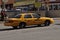 A taxicab pulling into a taxi parking area