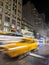 Taxis and buses driving down 5th Avenue in New York City at night with motion blur effect