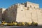 Taxis wait for passengers in from of the medina wall in Sfax, Tunisia.