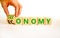 Taxonomy or economy symbol. Businessman turns wooden cubes and changes the concept word Economy to Taxonomy. Beautiful white