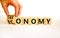 Taxonomy or economy symbol. Businessman turns wooden cubes and changes the concept word Economy to Taxonomy. Beautiful white