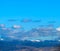 Tbilisi cityscape with snowy mountains and puffy clouds