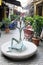 Tbilisi, Georgia - June 7, 2019: Statue of a man sitting and raising his hands up on a narrow street in the city center.