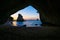 Te Hoho Rock standing in sun framed by the natural arch of Cathedral Cove on Coromandel Peninsula New Zealand