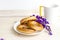 Tea with bagels. Butter the bagels. Fragrant tea. Light composition with bright and purple flowers.