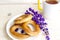 Tea with bagels. Butter the bagels. Fragrant tea. Light composition with bright and purple flowers.