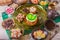Tea break with a delicious honey cake decorated in the form of a green apple and a variety of multi-colored small candies. Copper