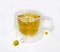 Tea with chamomile in a glass cup on a white background, concept of ecology, medicinal tea, summer