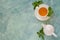 Tea concept. Teapot and cup with green herbal tea decorated mint leaves on wooden background.