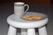 Tea cup and biscuits placed on a white stool