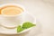 tea cup with a lemon and mint/tea cup with a lemon and mint on a white marble background closeup. Selective focus