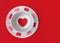 Tea cup and saucer with love hearts on a red background. Flat lay with copy space