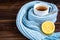 Tea cup with thermometer, blue scarf and lemon on wooden background. Flu season, disease