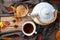 tea cup and a white teapot on a wooden table with spices and some autumn leaves, high angle view from above, selected focus