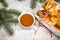 Tea with gingebread cookies in christmas evening. Cup near spruce branch on white wooden background top view copyspace