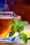 Tea in a glass bottle, mint leaves, dried tea, sliced lime, cane sugar