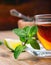 Tea in a glass cup, mint leaves, dried tea, sliced lime, cane sugar