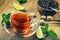Tea in a glass cup, mint leaves, dried tea, sliced lime, cane sugar
