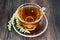 Tea with gray wormwood in glass cup on dark board