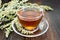 Tea with gray wormwood in glass cup on table