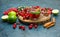 Tea with herbs, fruits, spices in a mug on wooden board and stucco background, high angle view