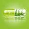 Tea leaves in capsule vitamin light green. Medical concepts and health supplements.