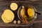 Tea with lemon in cup, cinnamon, spoon on saucer, wafers, sugar, half of lemon on wooden table. Top view