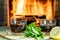 Tea with lemon and mint in glass cups in front of burning fireplace in a country house