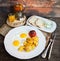 Tea with lemon and plate of breakfast food with eggs, tomato, to