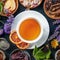 Tea, overhead square shot. Leaves, flowers and fruit around a cup of tea