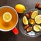 Tea in a red mug. Slices of juicy lemon, dates and spoon of hone