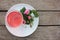 Tea rose herbal tea in a glass cup with pink buds and flowers on a rustic wooden table. Summer tea party outdoors