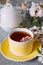 Tea served in a yellow teacup and saucer decorated with spring flowers