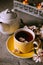 Tea served in a yellow teacup and saucer decorated with spring flowers