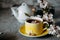 Tea served in a yellow teacup and saucer decorated with spring flowers